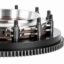 Load image into Gallery viewer, Clutch plate with a tan friction material outer ring, a copper-toned center, a black splined hub