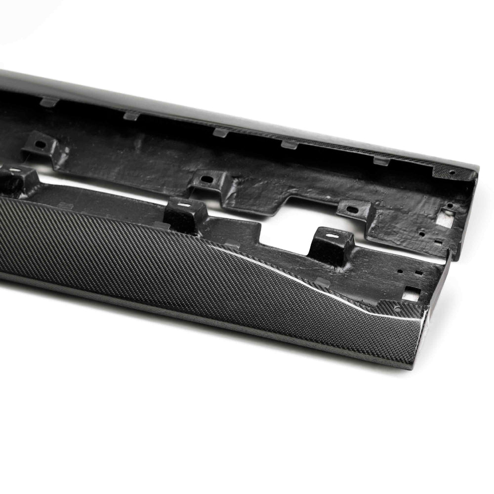 Pair of GT350-style carbon fiber rocker splitters for 2015–2017 Ford Mustang laid flat, highlighting curvature and precision fitment.