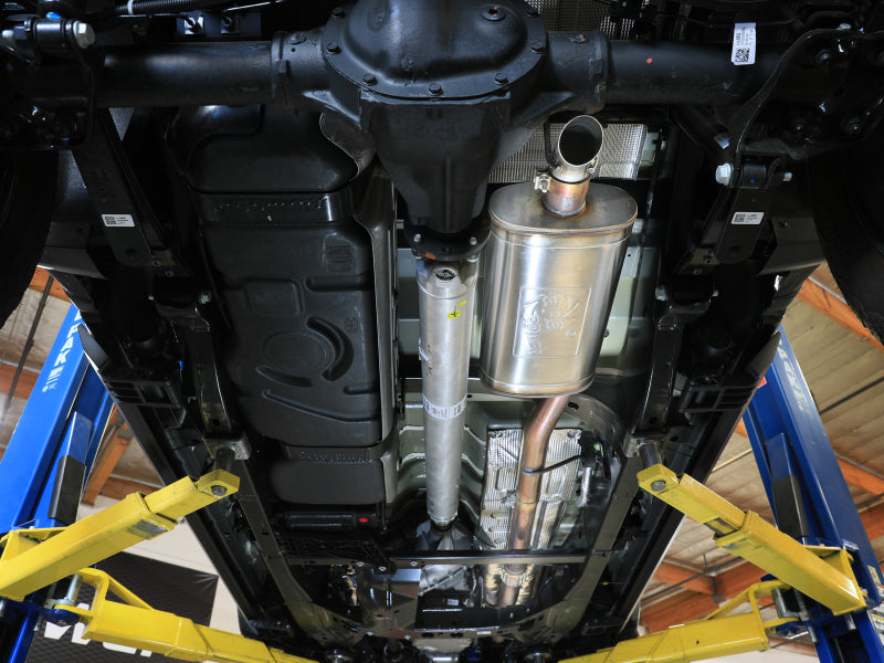 aFe Rock Basher exhaust system installed underneath a truck on a lift, full underbody view