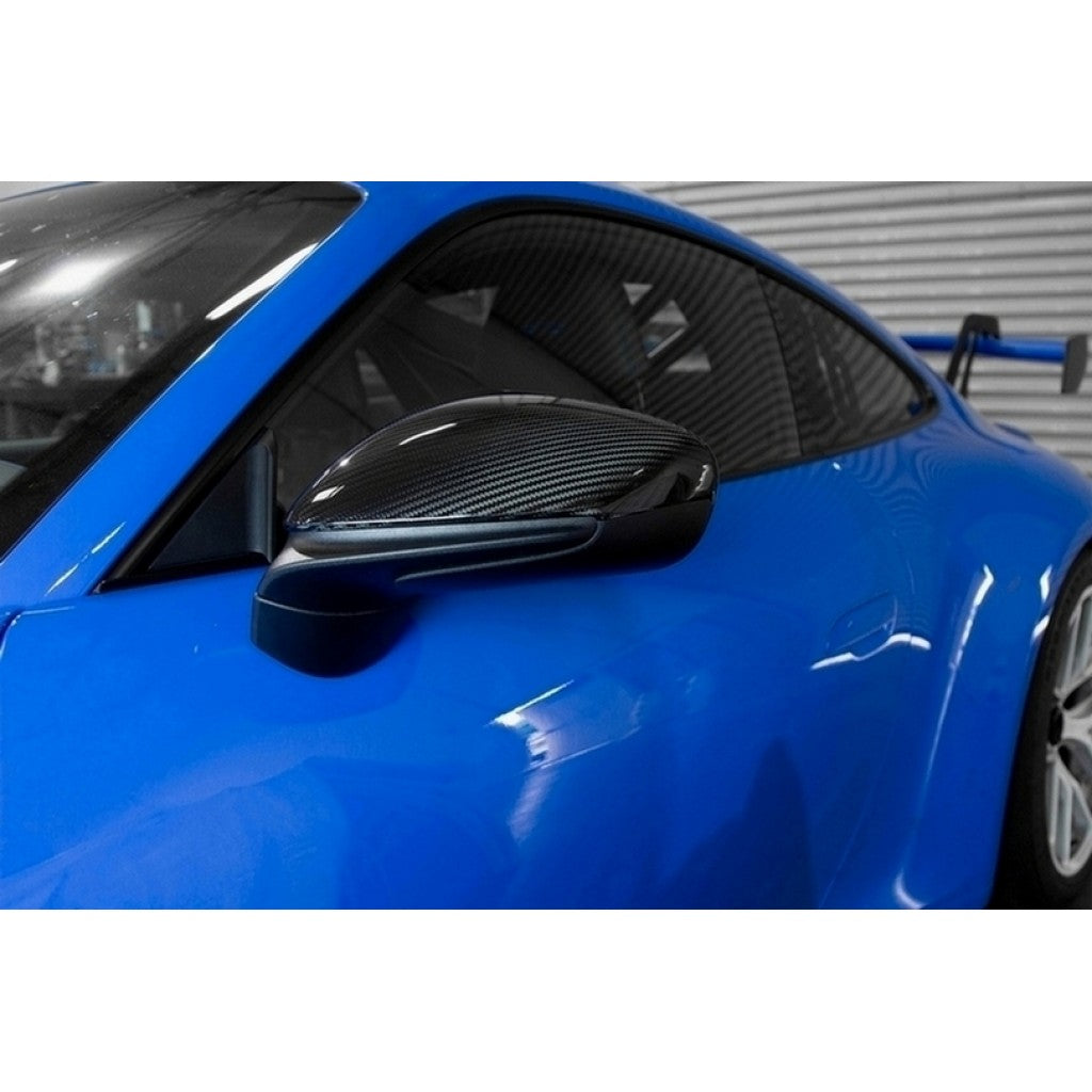 APR Performance carbon fiber mirror cover installed on blue Porsche 911 992 side view