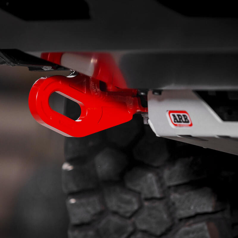 Representative detail view of the shackle eye on a red ARB forged recovery point fitted to a Toyota Land Cruiser 250, photographed with an ARB skid plate that is not included