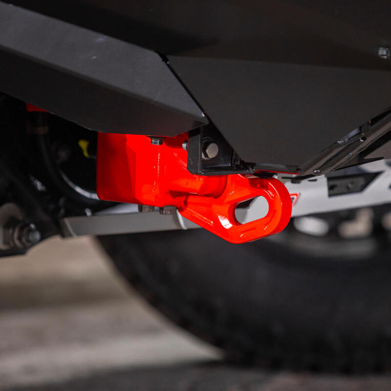 Representative installed close up of a red ARB forged recovery point under the front of a Toyota Land Cruiser 250, shown with under vehicle protection panels that are not included
