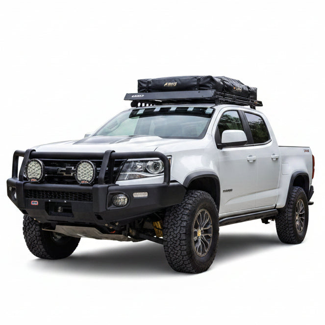 Representative installed view of an ARB Summit winch bumper on a white Chevrolet Colorado ZR2, front three quarter angle, shown with driving lights, roof rack and rooftop tent that are not included