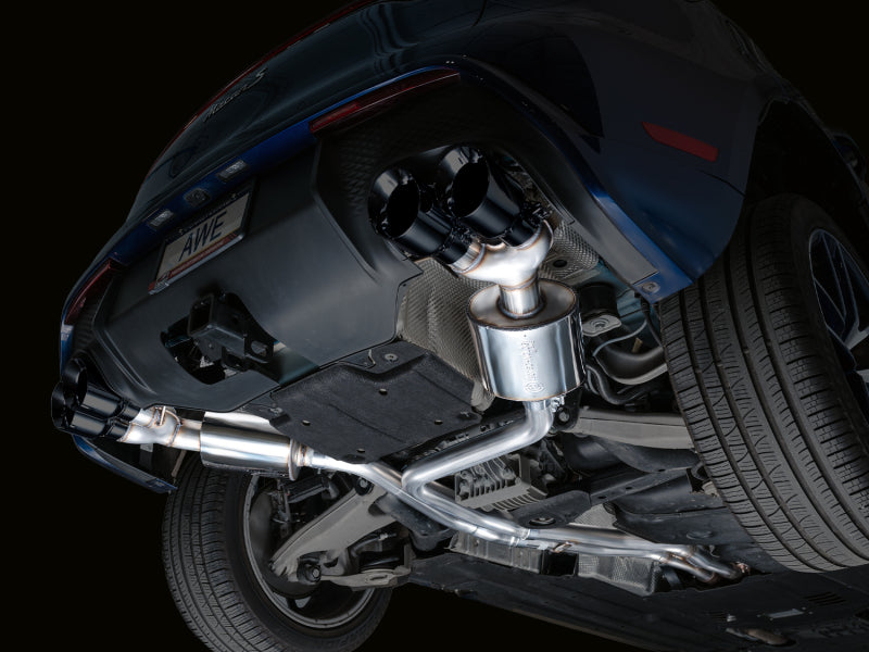 Front underside view of Porsche Macan 2.9TT showing installed AWE Tuning Touring Edition Catback Exhaust piping and components