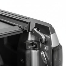 Load image into Gallery viewer, Close-up of the BAKFlip G2 folded panel stack and side rail clamp at the cab end