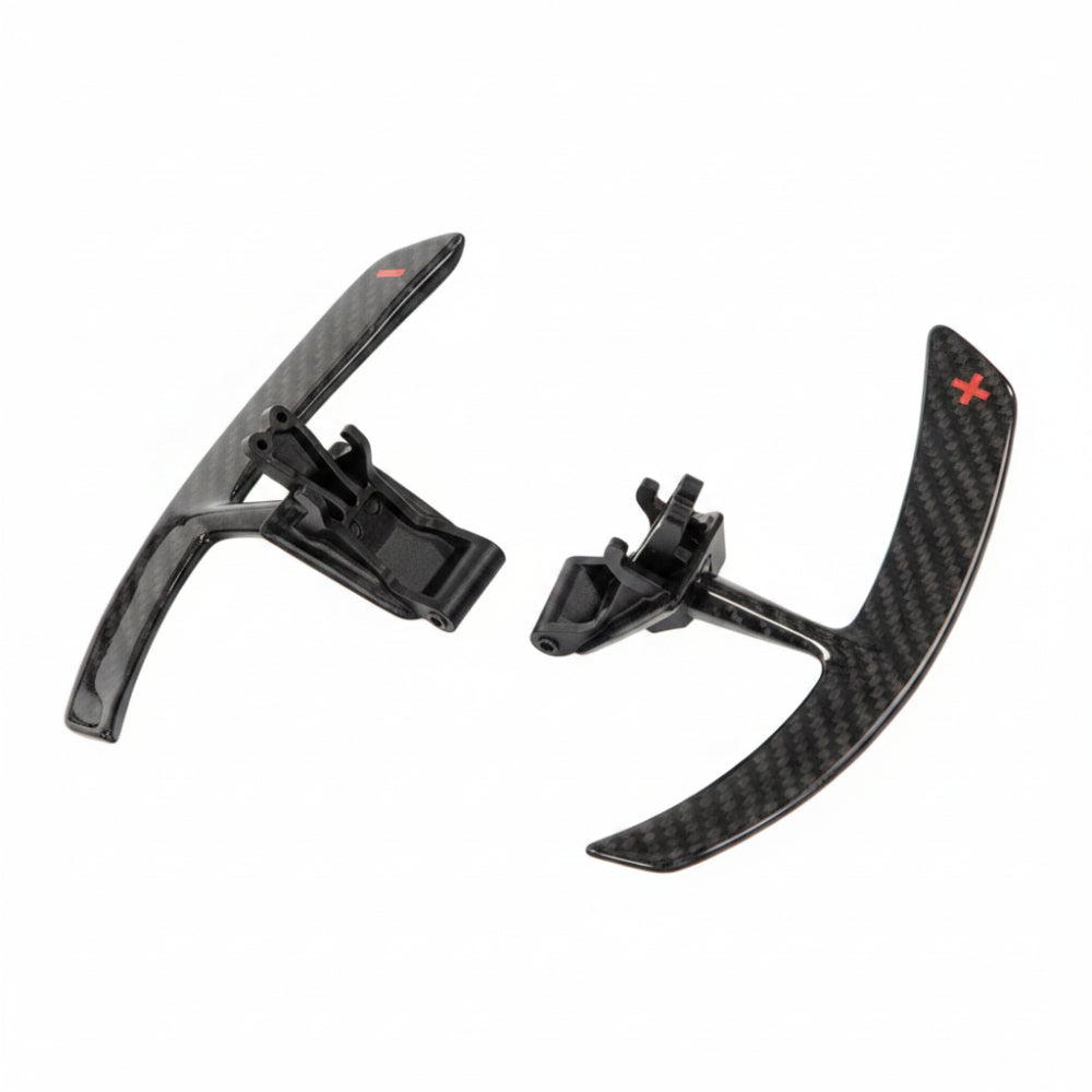 Pair of Porsche 991 carbon fiber paddle shifter extensions with black mounting brackets, photographed at an angle