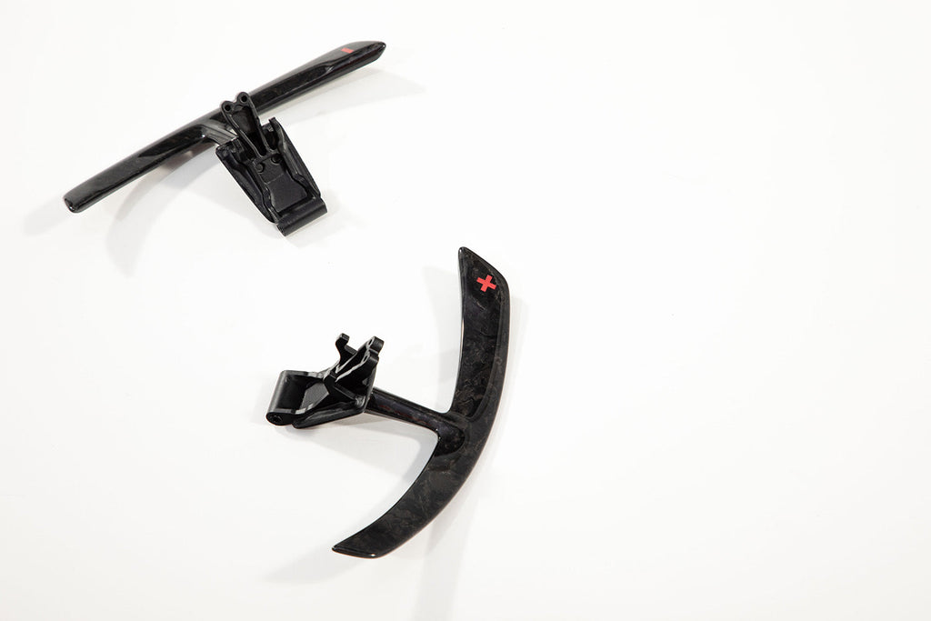 Porsche 991 carbon paddle shifter extension pair photographed small in frame against a plain background