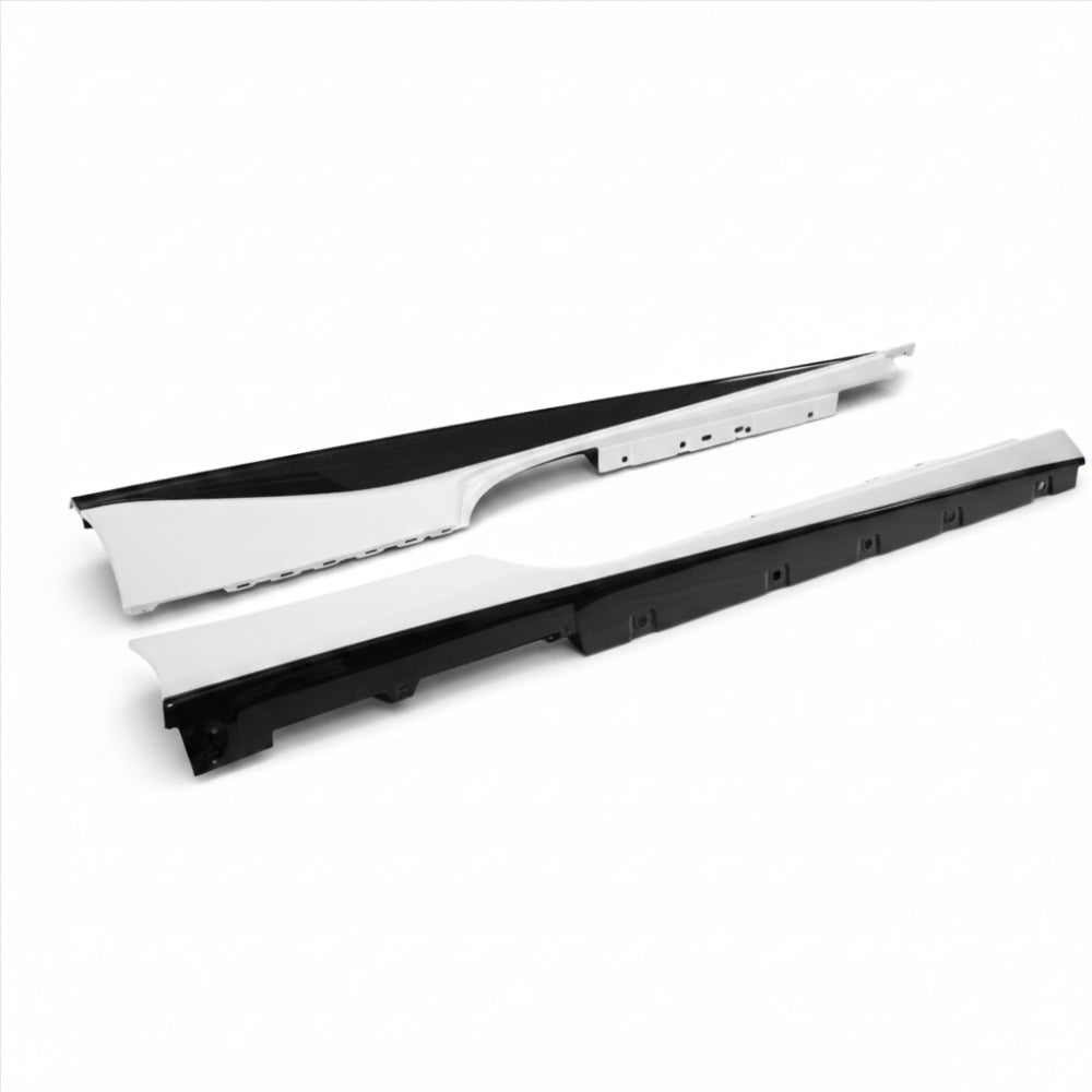 Pair of Ferrari 488 side skirts with white painted upper sections and gloss carbon fiber lower blades, laid side by side