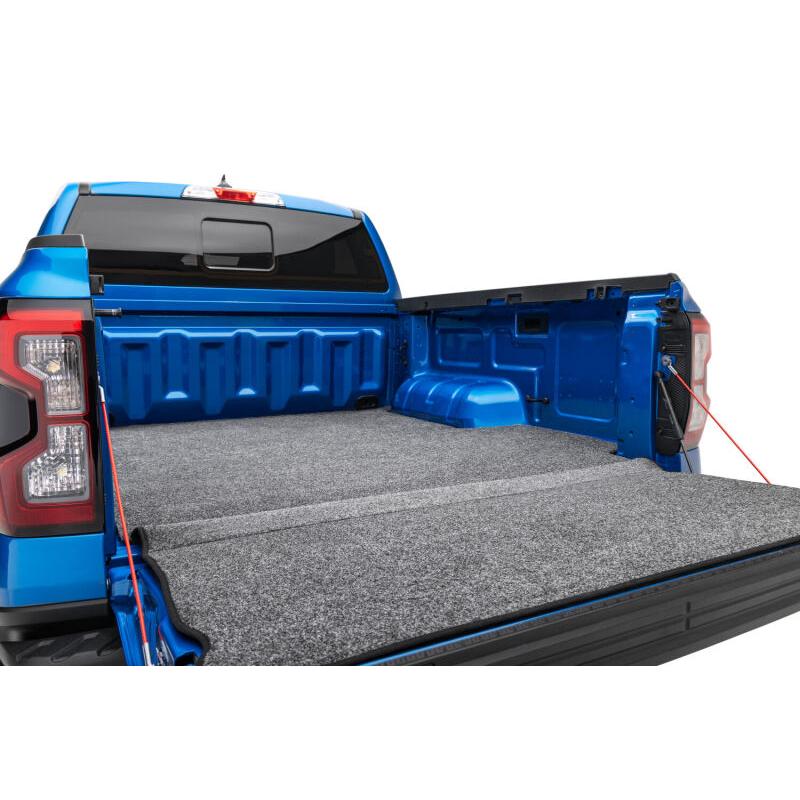 Husky Liners bed liner installed in a blue truck bed, rear tailgate-down view