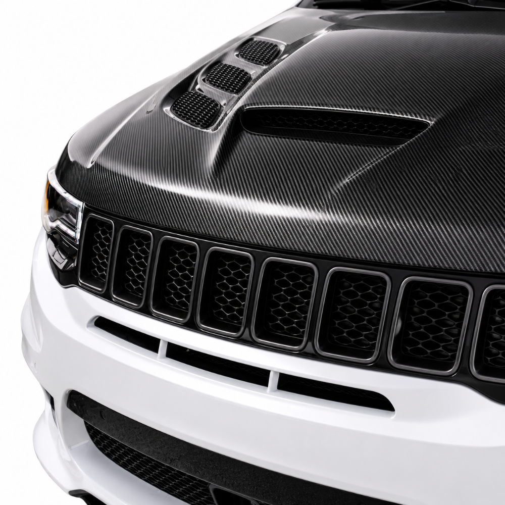 Close-up from the front of the installed carbon Sniper hood showing the centre scoop above the grille