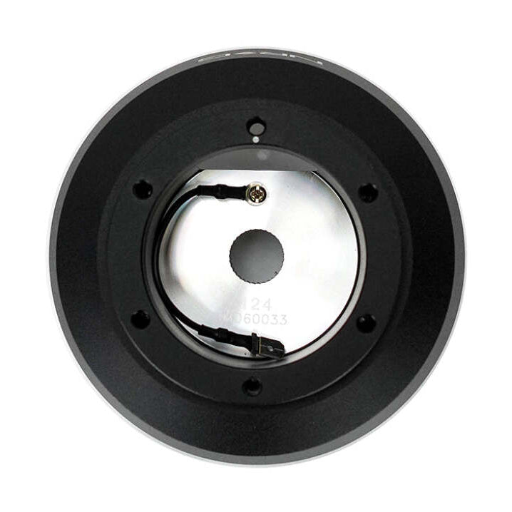 Front face of the NRG SRK-124H short hub adapter with six mounting holes around a polished horn contact plate