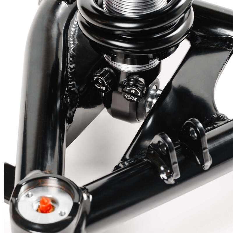Close-up of QA1 coilover mount assembly showing compression and rebound adjustment knobs on front suspension kit for 99-06 Chevy Silverado 1500 2WD.