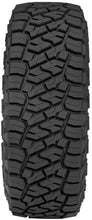 Load image into Gallery viewer, Toyo R/T Trail tire demonstrating aggressive off-road traction in mud/rocks