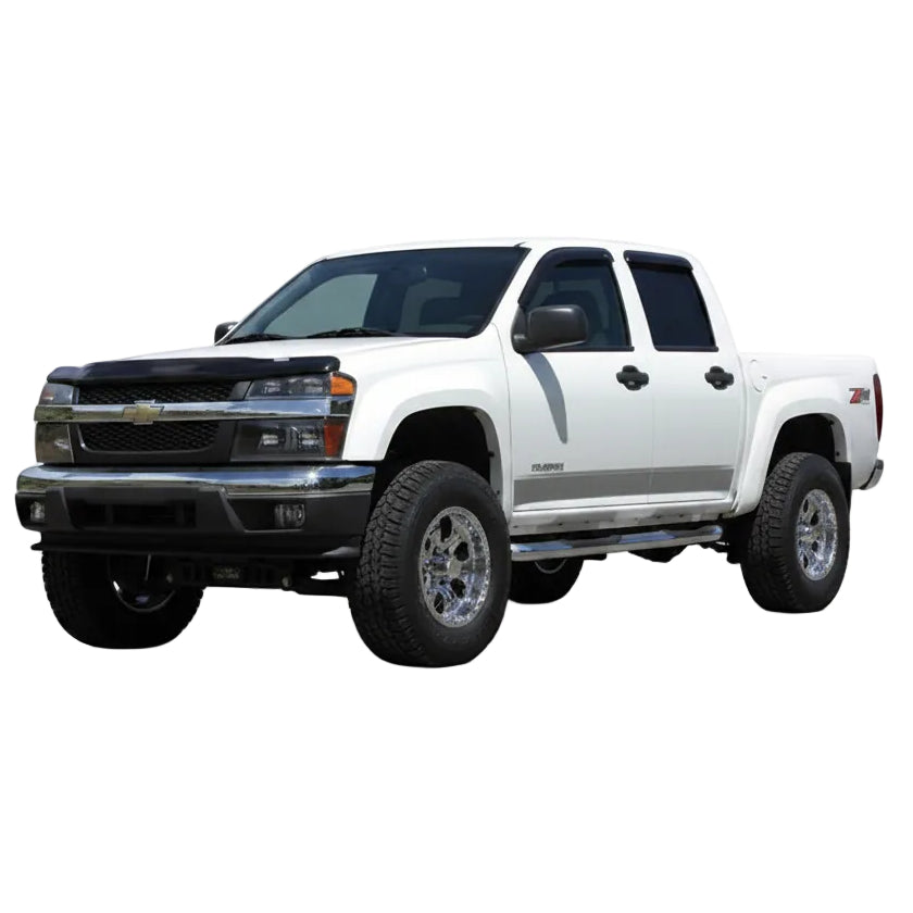 White lifted Chevy Colorado 4x4 with Tuff Country lift kit installed, front three-quarter view on a dirt road